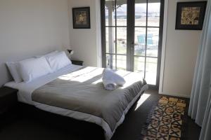 a bedroom with a bed with a hat on it at Pedalfish Cottage in Twizel