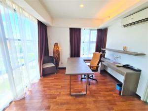 ein Büro mit einem Schreibtisch sowie einem Tisch und Stühlen in der Unterkunft Nexus Business Suite Hotel in Shah Alam