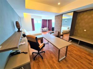 a living room with a desk and a table with a chair at Nexus Business Suite Hotel in Shah Alam
