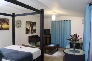 1 dormitorio con cama y cortina azul en Stephna Residence en Anse Boileau