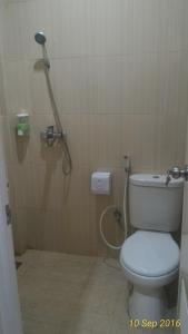 y baño con ducha y aseo. en Omnea Hotel - Syariah, en Bengkulu