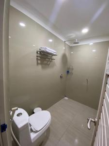 a small bathroom with a toilet and a shower at Wisma Lovebird in Kalianget