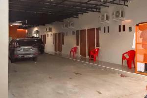 a car parked in a garage with red chairs at RedDoorz Syariah @ Haurgeulis in Baoen
