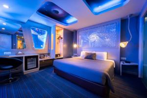 Maison Boutique Theme Hotel Kuala Lumpur by Swing & Pillows في كوالالمبور: غرفة نوم بسرير في غرفة ذات اضاءة زرقاء