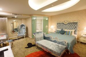 um quarto com uma cama, uma cadeira e um espelho em Maison Boutique Theme Hotel Kuala Lumpur by Swing & Pillows em Kuala Lumpur