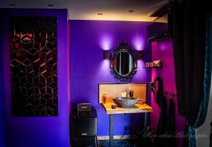 Baño púrpura con lavabo y espejo en La Magie d'une Nuit en Agde