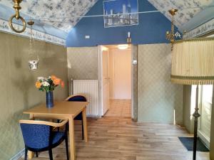 a dining room with a wooden table and blue chairs at B&B Altijd Welkom in Ruinen