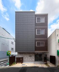 un grand bâtiment avec une façade noire dans une rue dans l'établissement GRAND BASE Okayama Ekimae, à Okayama