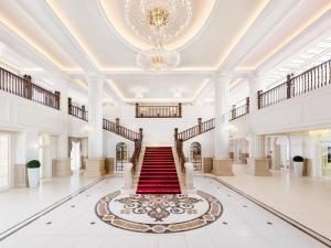 a large lobby with a red carpet and a chandelier at Takarazuka Hotel in Takarazuka