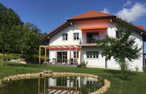 a house with a pond in front of it at LICHTECK - Helle Ferien in Breitenberg