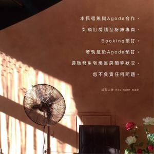 a fan is sitting in a room with a wall at Red Roof B&B in Taitung City