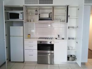 a kitchen with white appliances and white cabinets at RNR North Terrace in Adelaide