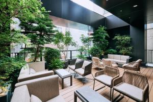 a lobby with chairs and tables and plants at NOHGA HOTEL AKIHABARA TOKYO in Tokyo
