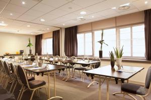 a conference room with tables and chairs and windows at Escale Oceania Quimper Centre in Quimper