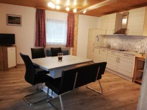uma cozinha e sala de jantar com mesa e cadeiras em Simonbauerhof em Bad Kleinkirchheim