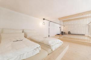 a white room with two beds and a window at NaturparkResort Alte Schule in Hieflau