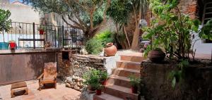 einen Garten mit einer Bank und einem Tisch und einigen Pflanzen in der Unterkunft Chambres d'hôtes Can Oliba in Elne