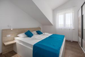 a white bed with blue sheets in a room at Villa Ancora in Rovinj +80 photos