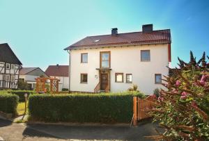 uma casa branca com uma cerca num quintal em Ferienwohnung “Mount Meißner” em Germerode