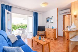 a living room with a blue couch and a table at Duna Villa, Cala Blanca in Cala Blanca