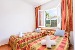 two beds in a room with a window at Duna Villa, Cala Blanca in Cala Blanca +20 photos