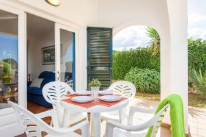 a white table and chairs on a patio with a view of the ocean at Duna Villa, Cala Blanca in Cala Blanca