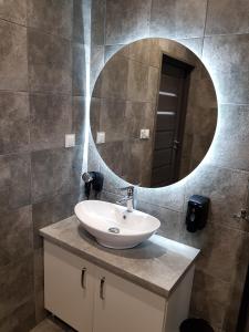 een badkamer met een wastafel en een spiegel aan de muur bij Osada Orlica 1 in Lasowka