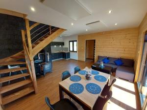 a living room with a dining table and a staircase at Osada Orlica klimatyczne domki z widokiem na góry i termalnym SPA sauna jacuzzi 4 km od Zieleniec Ski Arena in Lasowka