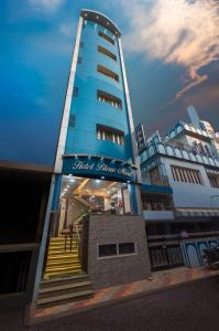 um edifício azul alto com escadas em frente em Hotel Bleue Mont em Varanasi