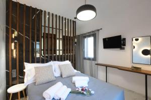 a bedroom with a blue bed with white pillows at Orion Eco Suites in Karteros