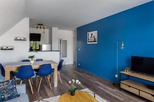 sala de estar con pared azul, mesa y sillas en Apartment Epinette 2 bedroomed near Disneyland Paris, en Magny-le-Hongre