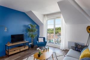 a living room with a blue accent wall at Apartment Epinette 2 bedroomed near Disneyland Paris in Magny-le-Hongre