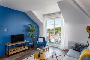 ein Wohnzimmer mit einer Wand mit blauen Akzenten in der Unterkunft Apartment Epinette 2 bedroomed near Disneyland Paris in Magny-le-Hongre