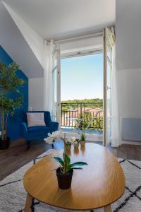 ein Wohnzimmer mit Tisch und großem Fenster in der Unterkunft Apartment Epinette 2 bedroomed near Disneyland Paris in Magny-le-Hongre