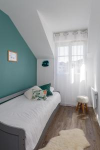 ein Schlafzimmer mit einem Bett mit einer blauen Wand in der Unterkunft Apartment Epinette 2 bedroomed near Disneyland Paris in Magny-le-Hongre