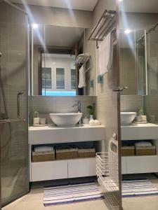 a bathroom with two sinks and a shower at A Cosy Apartment in Vinhomes Green Bay Ha Noi in Hanoi