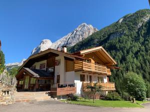 a house with a mountain in the background at Appartamenti Chalet Orchidea in Canazei