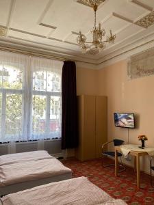 a bedroom with a bed, desk, chair and a television at Hotel Gunia in Berlin