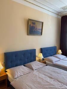 a bedroom with two beds and a painting on the wall at Hotel Gunia in Berlin