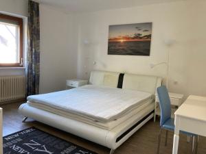 ein Schlafzimmer mit einem Bett, einem Schreibtisch und einem Tisch in der Unterkunft Ferienwohnung Brenderweg in Koblenz