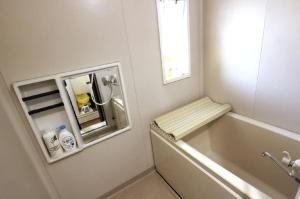 a bathroom with a bath tub and a window at コーポアス in Nikko +58 photos