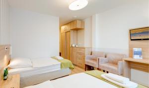 une chambre d'hôtel avec un lit et une chaise dans l'établissement Dozamel, à Kołobrzeg