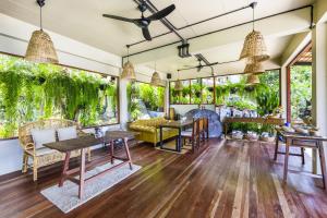 a living room with tables and chairs and plants at Baan Talay Koh Tao Resort & Yoga in Ko Tao