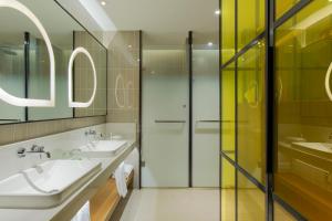 a bathroom with two sinks and a shower at Holiday Inn & Suites Tianjin Downtown, an IHG Hotel in Tianjin