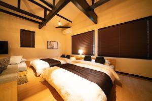 three beds in a room with blinds on the windows at EAST ONE Higashishinjuku in Tokyo