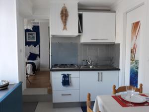 een keuken met witte kasten en een tafel met een eetkamer bij Cale In in Port-Louis