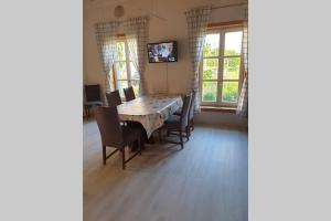 - une salle à manger avec une table, des chaises et des fenêtres dans l'établissement 2 Ferienhaus Andermichlhof, à Geltendorf