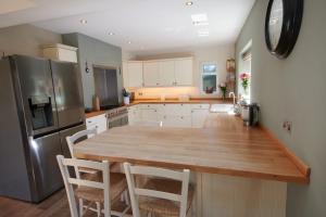 uma cozinha com uma mesa de madeira e um frigorífico em No.3 Buckland Cottages em Lymington
