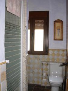 a bathroom with a toilet and a window at La Tiná in Segura de la Sierra