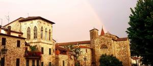 a large stone building with a tower and a church at La Torre di Pieve in Pieve Santo Stefano